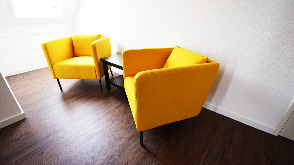 Gele stoelbanken en een zwarte salontafel